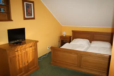 a bedroom with a bed and a flat screen tv at Hotel Bouček in Mochov