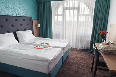 a hotel room with a bed with a red ribbon on it at Hotel Galatea in Mladá Boleslav