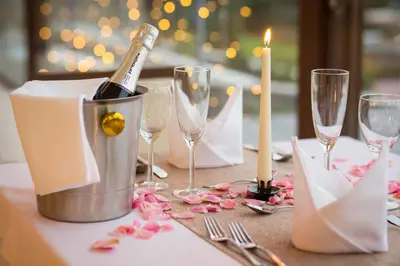 a table with a bottle of champagne and glasses on it at Hotel Galatea in Mladá Boleslav