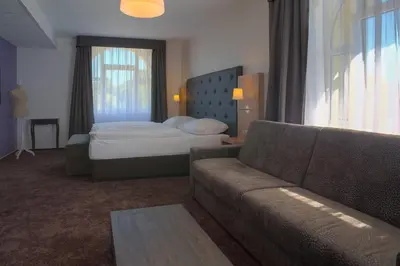 a living room with a couch and a bed at Hotel Galatea in Mladá Boleslav