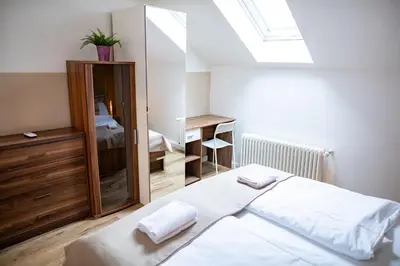 a bedroom with a bed with white sheets and a mirror at Central 3bdr penthouse with terrace&AC in Prague