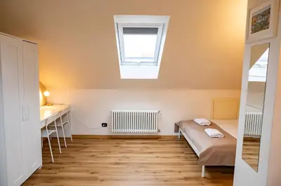a small room with a bed and a window at Central 3bdr penthouse with terrace&AC in Prague