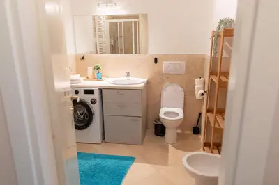 a bathroom with a toilet and a sink and a washing machine at Central 3bdr penthouse with terrace&AC in Prague