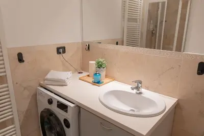 a bathroom with a sink and a washing machine at Central 3bdr penthouse with terrace&AC in Prague