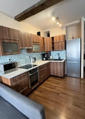 a kitchen with wooden cabinets and a stainless steel refrigerator at Hip Prague Area Central Flat in Prague