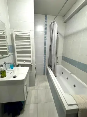 a white bathroom with a tub and a sink and a bath tub at Hip Prague Area Central Flat in Prague