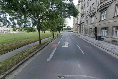 an empty street with trees on the side of a building at Hip Prague Area Central Flat in Prague