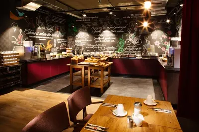 a restaurant with two wooden tables and a bar at Hotel PULSE8 in Prague