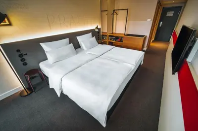 a large white bed in a room with a television at Hotel PULSE8 in Prague