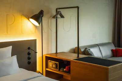a bedroom with a bed and a desk with a lamp at Hotel PULSE8 in Prague
