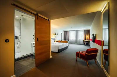 a hotel room with a bed and a bathroom at Hotel PULSE8 in Prague