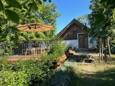 a house with a table and an umbrella in front of it at Vikendovka Korce in Dubá