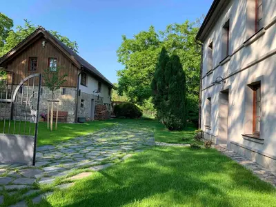 a stone path next to a house and a barn at Vikendovka Korce in Dubá