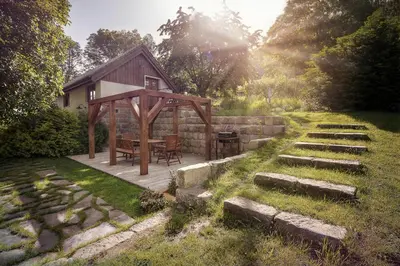 a house with a wooden deck with a table at Vikendovka Korce in Dubá