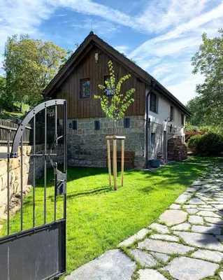 a gate in front of a house with a tree at Vikendovka Korce in Dubá