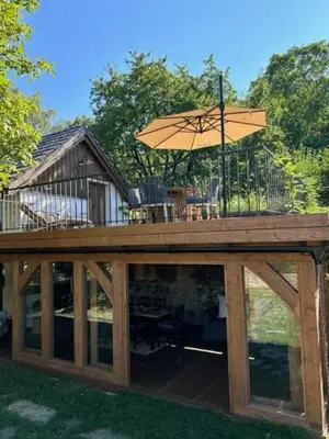 a wooden deck with an umbrella on top of it at Vikendovka Korce in Dubá