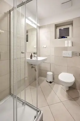 a bathroom with a shower and a toilet and a sink at HONEST Smichov in Prague