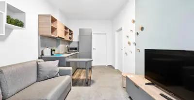 a living room with a couch and a flat screen tv at HONEST Smichov in Prague
