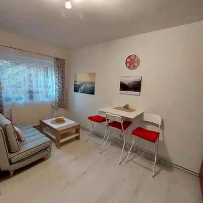 a living room with a desk and chairs and a table at Garsonka in Jílové u Prahy