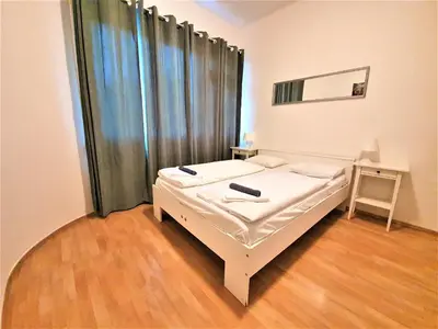 a bedroom with a bed and a table with a mirror at Epstein Apartments in Prague
