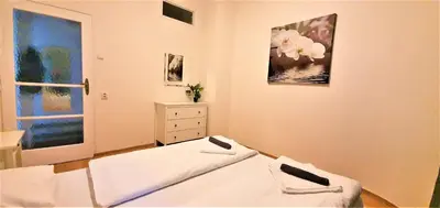 a white bedroom with two beds and a dresser at Epstein Apartments in Prague