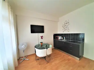 a room with a desk and a table and a tv at Epstein Apartments in Prague