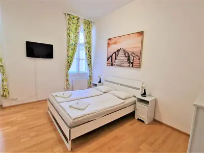 a bedroom with a bed and a flat screen tv at Reznicka Apartments in Prague
