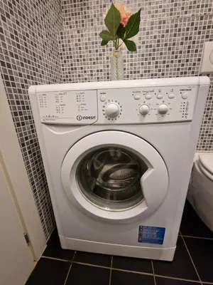 a washing machine in a bathroom with a vase with a plant at Reznicka Apartments in Prague