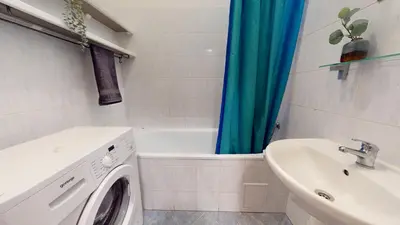 a bathroom with a washing machine and a sink at Apartmán Topolová 912B in Milovice