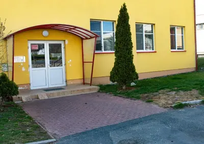 a yellow house with a white door and a tree at Apartmán Topolová 912B in Milovice