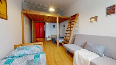 a bedroom with a bunk bed and a couch at Apartmán Topolová 912B in Milovice