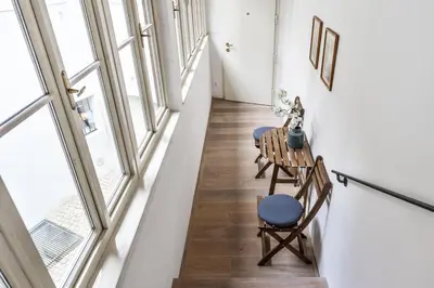 a hallway with a table and chairs and windows at COZY QUIET STUDIO AT CHARLES BRIDGE in Prague