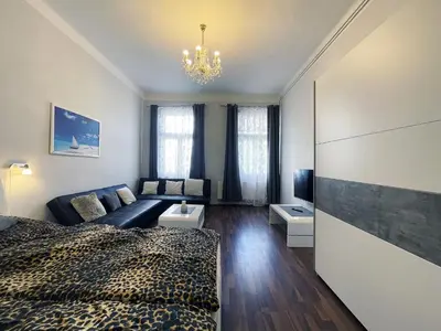a bedroom with a bed and a living room at Apartman Exclusive Prague in Prague