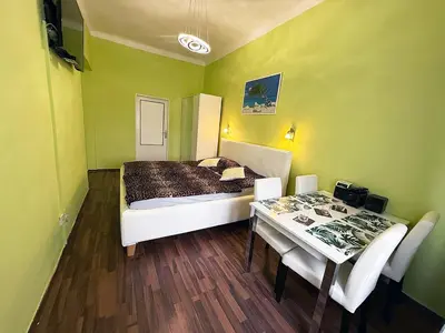 a bedroom with a bed and a table with chairs at Apartman Exclusive Prague in Prague