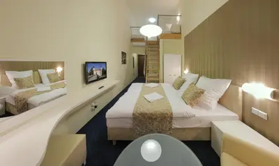 a hotel room with two beds and a staircase at Esmarin wellness hotel in Mníšek pod Brdy