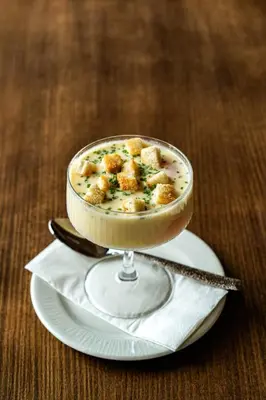 a bowl of soup in a glass dish on a plate at Esmarin wellness hotel in Mníšek pod Brdy