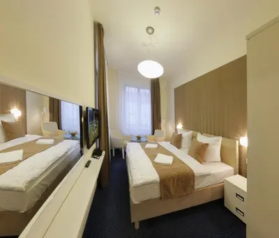 a hotel room with two beds and a large mirror at Esmarin wellness hotel in Mníšek pod Brdy