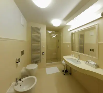 a bathroom with two sinks and a toilet and a mirror at Esmarin wellness hotel in Mníšek pod Brdy