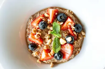 a plate of oatmeal with fruit and nuts at Esmarin wellness hotel in Mníšek pod Brdy