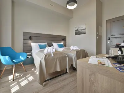 a hotel room with two beds and a blue chair at EA Hotel New Town in Prague