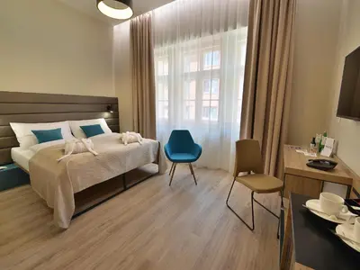 a hotel room with a bed and a blue chair at EA Hotel New Town in Prague