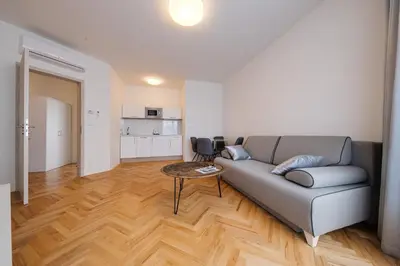 a living room with a couch and a tv at Gold Art Apartments in Prague