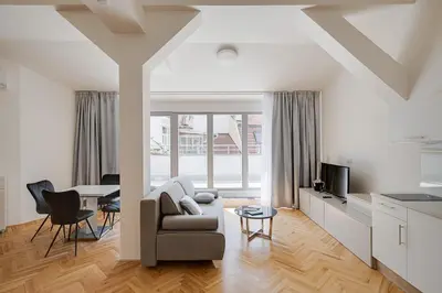 an attic room with a table and chairs in a house at Gold Art Apartments in Prague