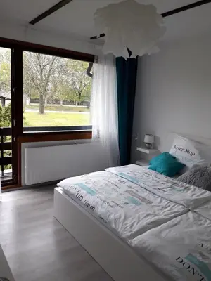 a white bed in a bedroom with a large window at Apartment 144 in Kněževes