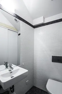 a bathroom with a sink and a mirror and a toilet at Our Loft at Charles Bridge in Prague