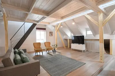 a living room with a couch and a tv at Our Loft at Charles Bridge in Prague