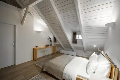 a bedroom with white walls and a bed in a room at Our Loft at Charles Bridge in Prague