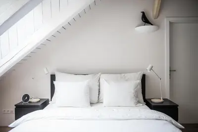 a bedroom with a white bed with white pillows at Our Loft at Charles Bridge in Prague