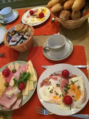 a table with plates of food and baskets of bread at Pension Karnet in Prague