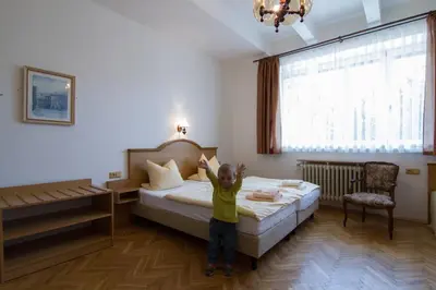 a little child standing in a hotel room at Pension Karnet in Prague
